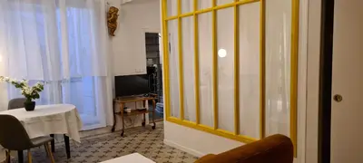 a living room with a table and a window at Havre de paix au coeur historique in Aix-en-Provence