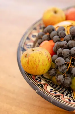 a bowl of fruit on a wooden table at Spacious villa in Provence in Le Puy-Sainte-Réparade