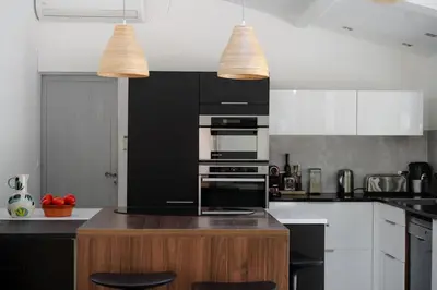 a kitchen with black and white appliances and two lights at Spacious villa in Provence in Le Puy-Sainte-Réparade