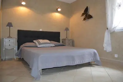 a bedroom with a bed with a butterfly on the wall at mas des oliviers in Gordes