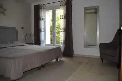 a bedroom with a bed and a chair and a window at mas des oliviers in Gordes