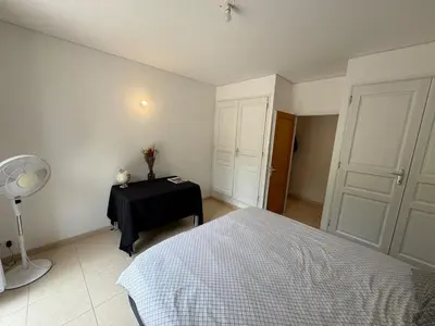 a bedroom with a bed and a table with a fan at Appartement dans Aix-en-Provence - Sainte Victoire in Saint-Marc-Jaumegarde