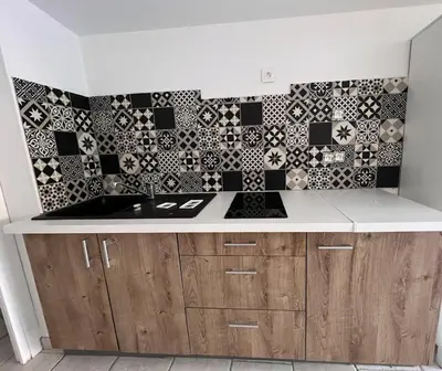 a kitchen with a sink and black and white tiles at Studio Velaux in Velaux