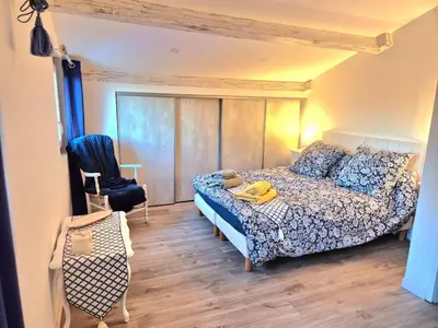 a bedroom with a bed and a chair at Villa grand confort, piscine privée, petanque, pool house in Alleins