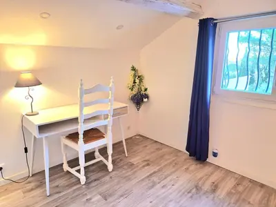 a desk and chair in a room with a window at Villa grand confort, piscine privée, petanque, pool house in Alleins