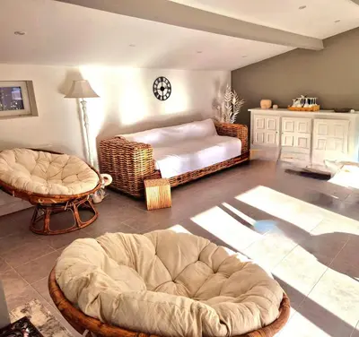 a living room with two ottomans and a bed at Villa grand confort, piscine privée, petanque, pool house in Alleins