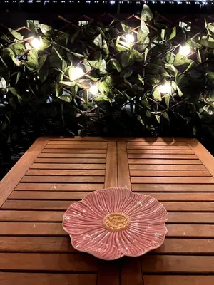 a pink umbrella sitting on a wooden floor with lights at Une Parenthèse Aixoise in Aix-en-Provence