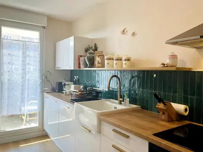 a kitchen with a white sink and green tiles at Une Parenthèse Aixoise in Aix-en-Provence