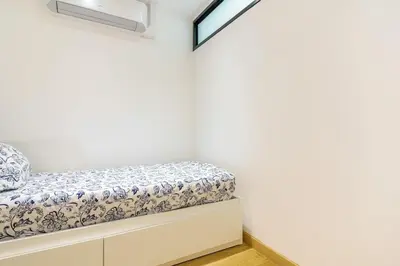 a bed in a room with white walls at T4 Aix PARKING CLIM refait a neuf in Aix-en-Provence