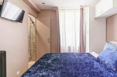 a bedroom with a blue bed with a tv on the wall at T4 Aix PARKING CLIM refait a neuf in Aix-en-Provence