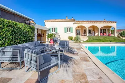 a patio with a couch and a table next to a pool at Villa Valleron by Villa Plus in Saint-Saturnin-les-Avignon