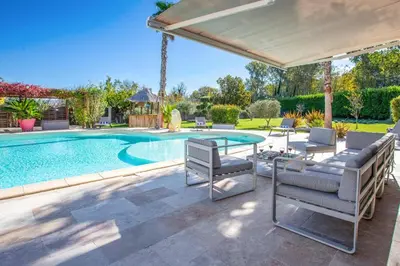 a swimming pool with a table and chairs next to a house at Villa Valleron by Villa Plus in Saint-Saturnin-les-Avignon