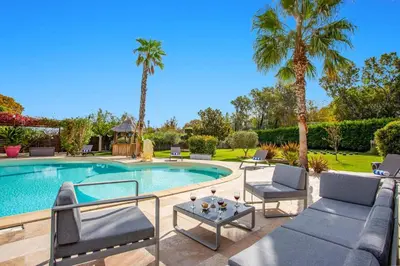a swimming pool with lounge chairs and a table next to a pool at Villa Valleron by Villa Plus in Saint-Saturnin-les-Avignon