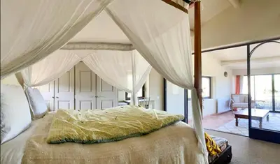 a bedroom with a canopy bed with curtains at Stone House Within Castle Ramparts In Goult in Goult