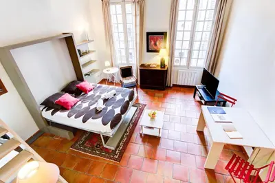 a bedroom with a bed and a desk in a room at Aude Loft in Aix-en-Provence