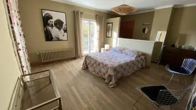 a bedroom with a bed and two chairs in it at agréable séjour en Luberon in Puget