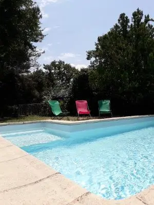 three chairs sitting next to a swimming pool at agréable séjour en Luberon in Puget