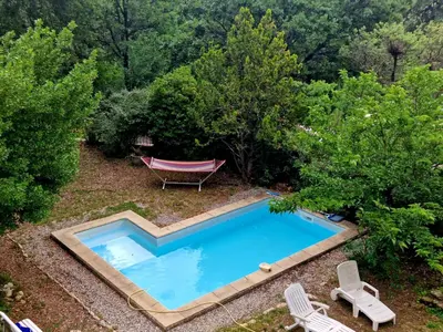 an overhead view of a swimming pool with a hammock and trees at agréable séjour en Luberon in Puget