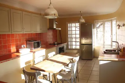 a kitchen with a wooden table and a refrigerator at agréable séjour en Luberon in Puget