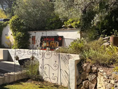 a gate in a garden with a stone wall at Maison V in Ventabren