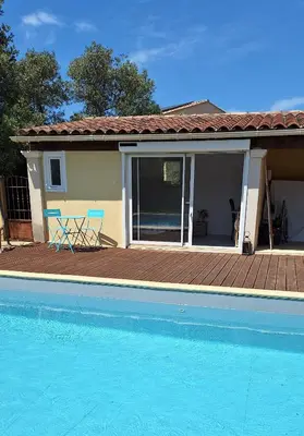 a house with a deck and a swimming pool at Le Jardin du Félibrige in Lançon-Provence