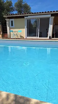 a large blue swimming pool in front of a house at Le Jardin du Félibrige in Lançon-Provence