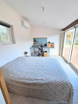 a bedroom with a large bed in a room with windows at Le Jardin du Félibrige in Lançon-Provence