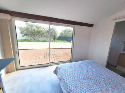 a bedroom with a bed and a large window at Le Jardin du Félibrige in Lançon-Provence