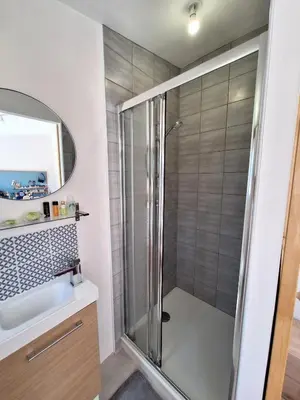 a shower with a glass door in a bathroom at Le Jardin du Félibrige in Lançon-Provence