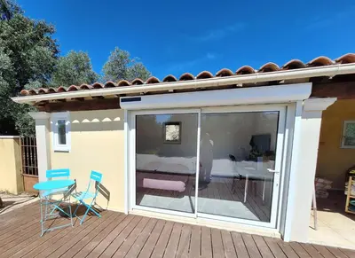 a patio with a sliding glass door with a table and chairs at Le Jardin du Félibrige in Lançon-Provence