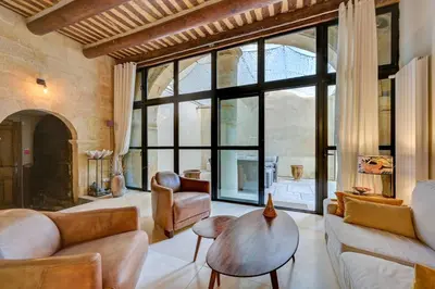 a living room with leather furniture and a large window at Beautiful duplex, historic center, private garden in Aix-en-Provence