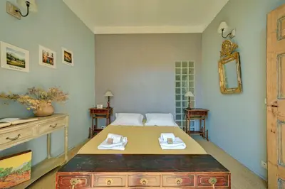 a bedroom with a large bed with a dresser and a mirror at Beautiful duplex, historic center, private garden in Aix-en-Provence