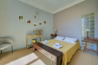 a bedroom with a bed with a table and a chair at Beautiful duplex, historic center, private garden in Aix-en-Provence