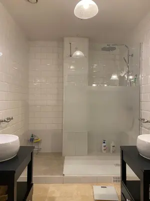 a bathroom with a shower and two sinks and a tub at Beautiful duplex, historic center, private garden in Aix-en-Provence