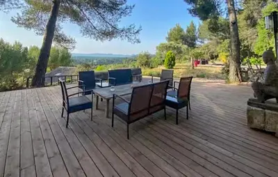 a patio with a table and chairs on a deck at Maison Piscine Proche Alpilles in Noves