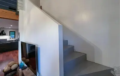 a staircase in a house with a white wall at Maison Piscine Proche Alpilles in Noves
