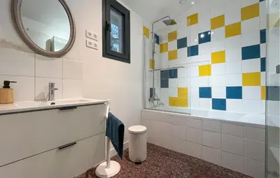 a bathroom with a sink and a tub and a mirror at Maison Piscine Proche Alpilles in Noves