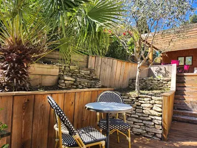 a patio with a table and chairs and plants at Domaine Les Gendalis in Saint-Saturnin-les-Avignon