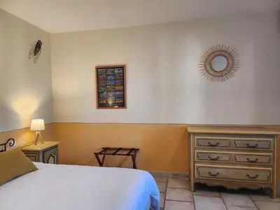 a bedroom with two twin beds and a dresser at Domaine Les Gendalis in Saint-Saturnin-les-Avignon