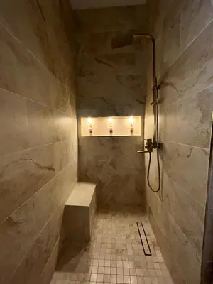 a walk in shower with a bench in a bathroom at Charmant appartement au centre ville de Cavaillon in Cavaillon