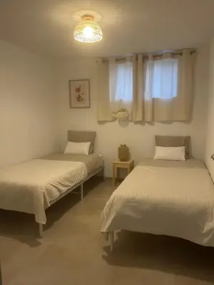 two beds in a room with two windows at Charmant appartement au centre ville de Cavaillon in Cavaillon