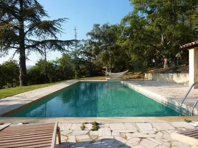 a swimming pool with a hammock in a backyard at cheznico jas d la plane in Bédoin
