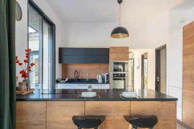 a kitchen with a large island with two chairs at Aria Blue - Spacieuse - Climatisée - Piscine in Lançon-Provence