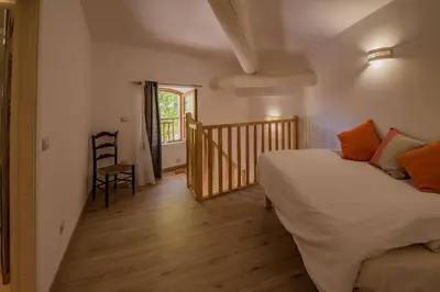 a bedroom with a bed and a wooden floor at Maison de village au cœur d'Eyguières Alpilles in Eyguières