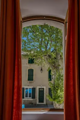 a large white bed in a room with a chair at Maison de village au cœur d'Eyguières Alpilles in Eyguières