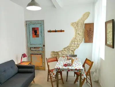 a living room with a table and a couch at Joli appartement centre village au calme in Châteaurenard