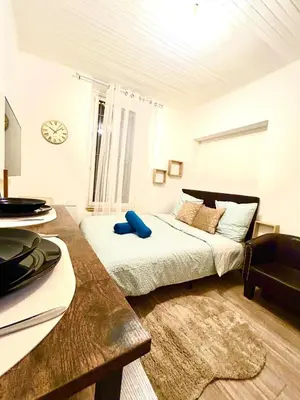 a white bedroom with a bed and a table at appartement,au luberon in Cavaillon