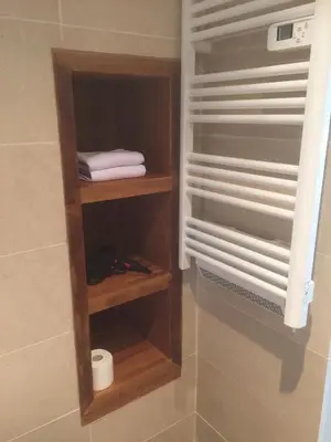 a closet with wooden shelves and towels in a bathroom at AJOUCADOU premiere loge in Lourmarin