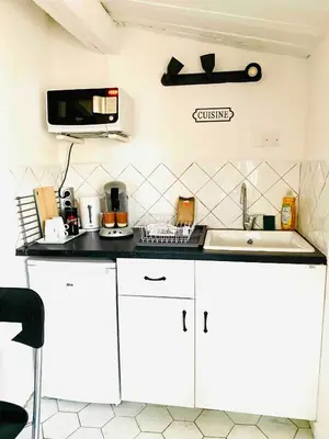 a kitchen with white cabinets and a sink and a microwave at Cocon cosy et calme au coeur du centre historique in Aix-en-Provence