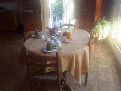 a table with a table cloth on it with cups and plates at Les Granges in Villars
